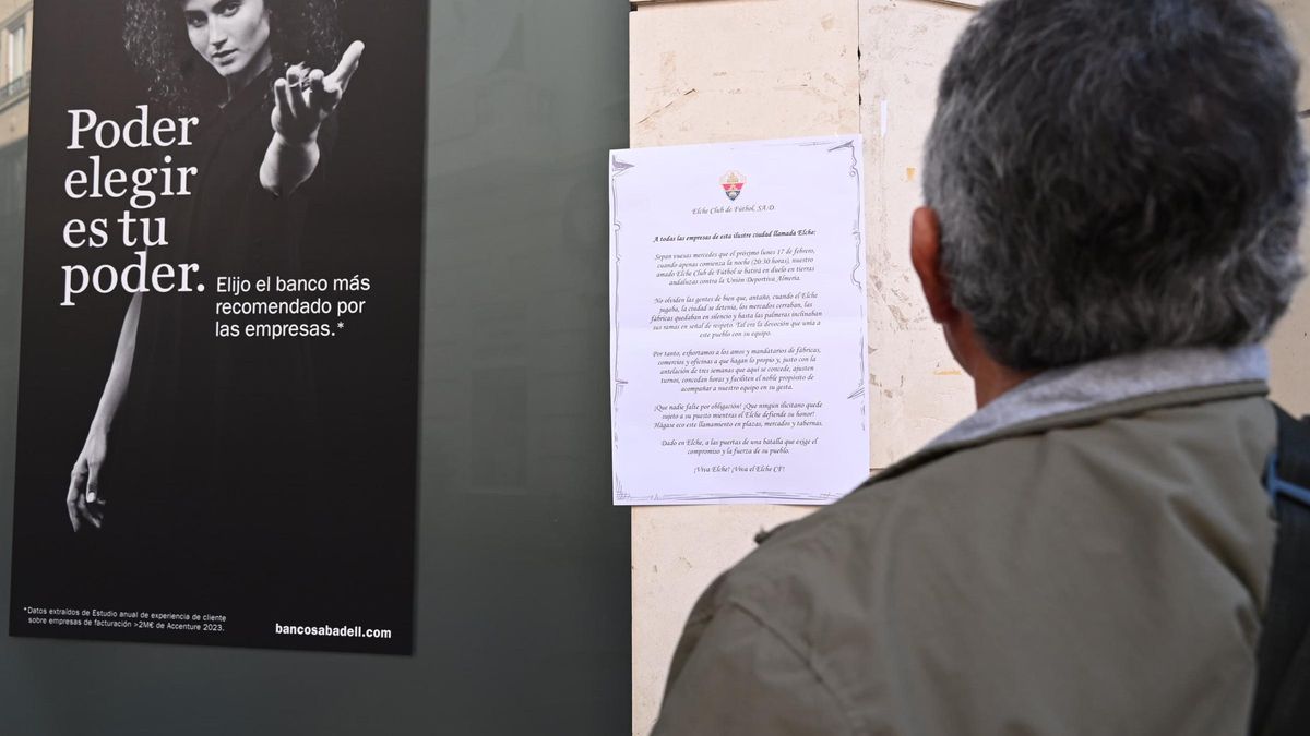 Un transeúnte lee el bando del Elche en el centro de la ciudad