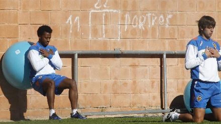 Manuel Fernandes y Ángel Dealbert realizan ejercicios musculares durante el entrenamiento de ayer.