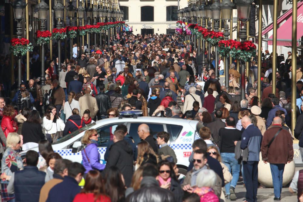 Muchos malagueños y turistas aprovechan el buen tiempo y el día festivo por la Inmaculada Concepción para pasear y realizar las compras navideñas en el Centro de Málaga.