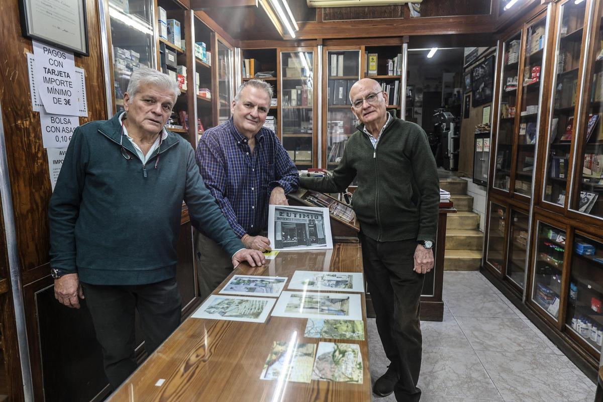 Los tres hermanos muestran una foto antigua del establecimiento.