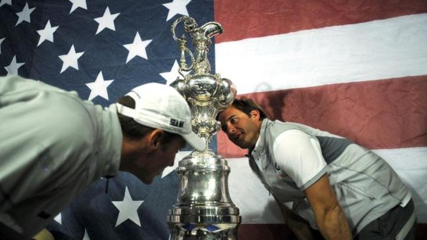 Dos miembros del BMW Oracle observan la jarra de las Cien Guineas, lograda ayer por el equipo tras imponerse al Alinghi suizo por 2-0, en la 33 edición de la Copa del América disputada en Valencia.