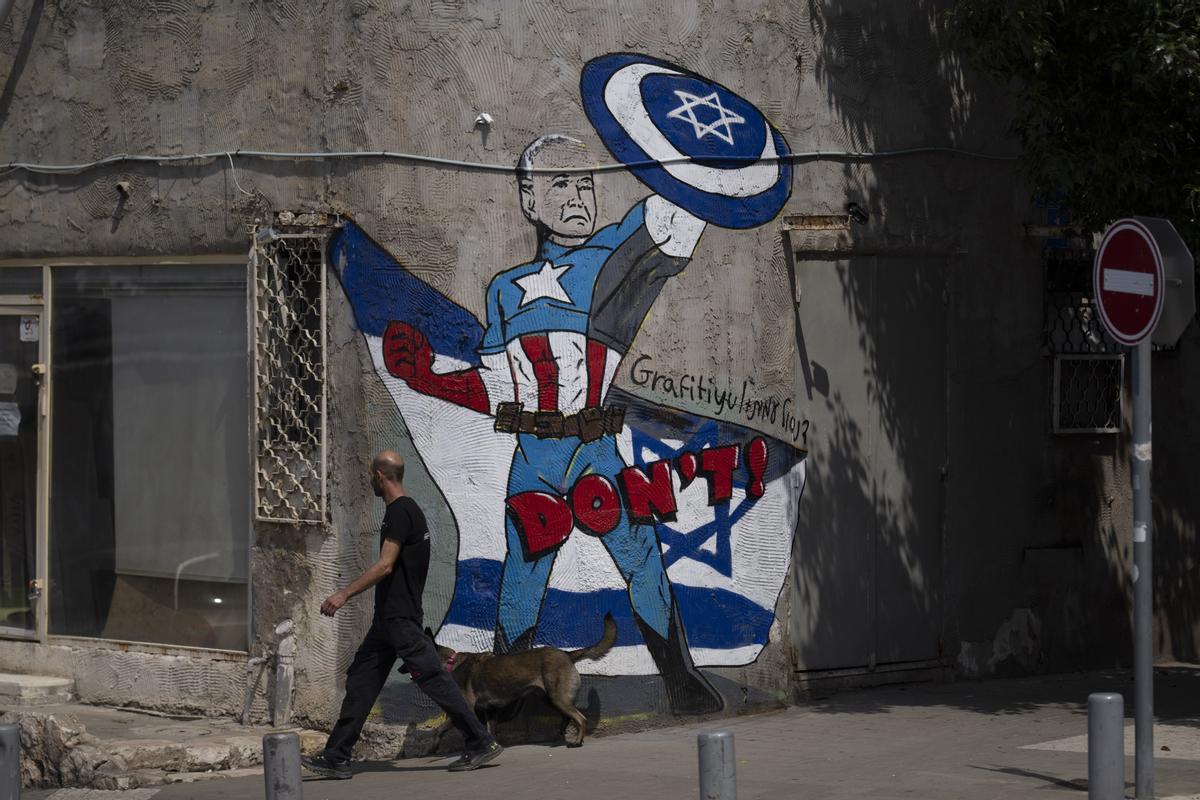 Un hombre pasa junto a un mural en Tel Aviv (Israel que representa al presidente de Estados Unidos, Joe Biden como si fuera el Capitán América