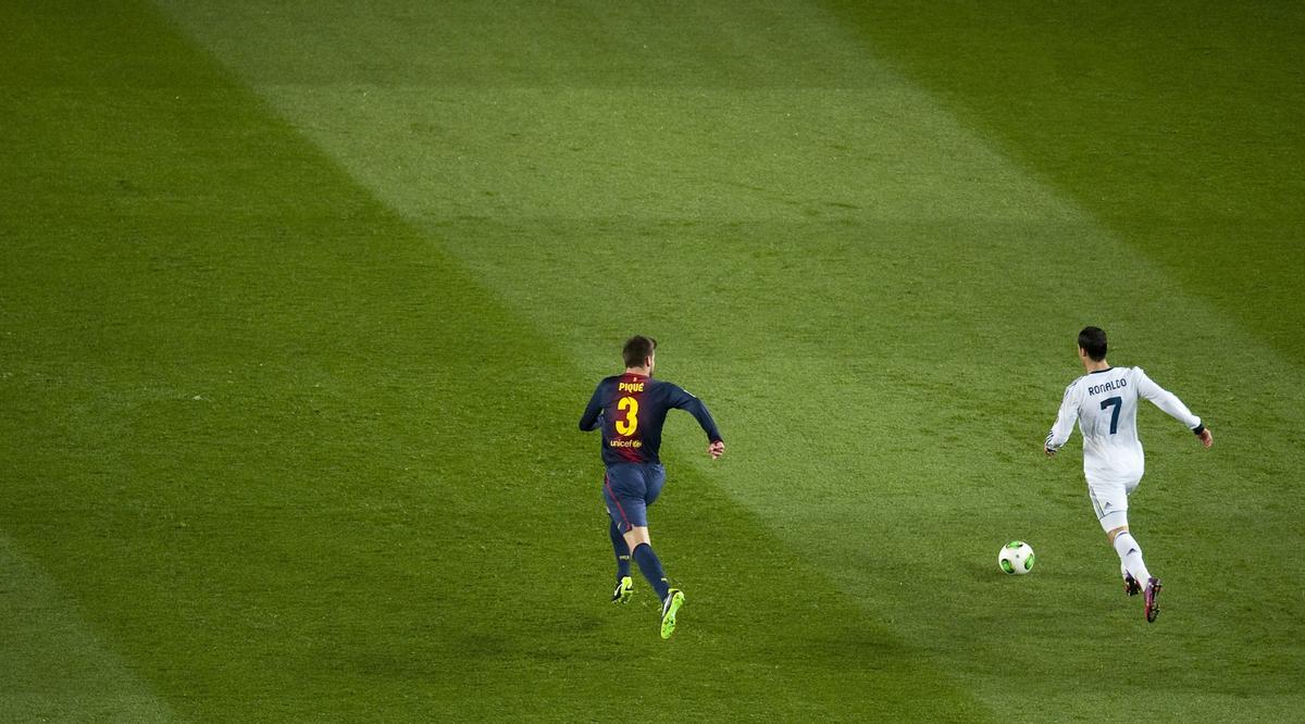 Cristiano Ronaldo vigilado por Piqué durante el partido de vuelta de las semifinales de la copa del rey entre el Barça y el Real Madrid, en febrero de 2013.