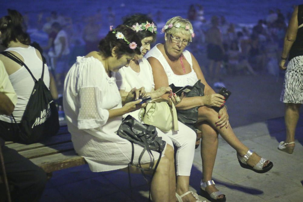 Noche de hogueras, baños, en las playas de la Vega Baja. En las imágenes grupos de amigos y familias en la playa del Cura de Torrevieja