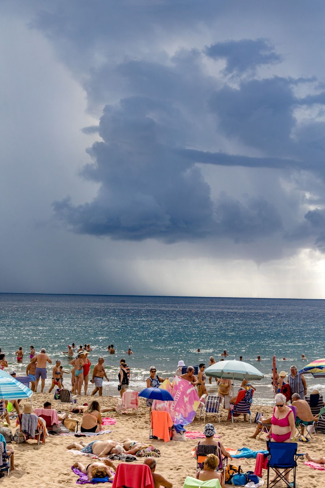 Los bañistas permanecen en las playas de Benidorm pese a la amenaza de lluvias