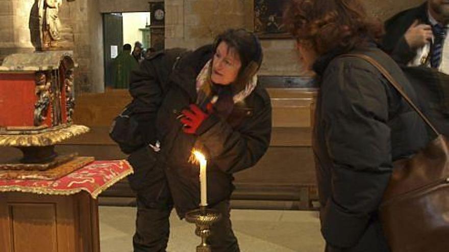 Dos personas observan la reliquia de san Valentín en La Colegiata.