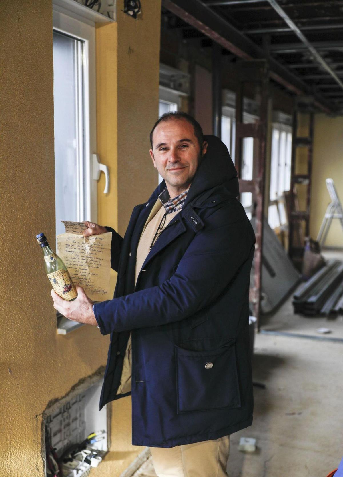 Alfredo Barro sostiene la botella en la que encontró la carta en el ático que está reformando en Gijón.