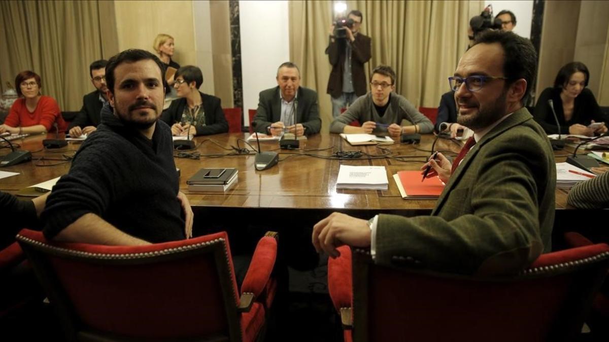 Los diputados Antonio Hernando, del PSOE, y Alberto Garzón, de IU, en primer plano de una reciente reunión 'a cuatro'.