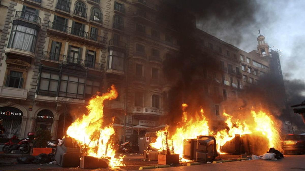 Varios contenedores arden en el centro de Barcelona, durante la huelga general del 29-M.
