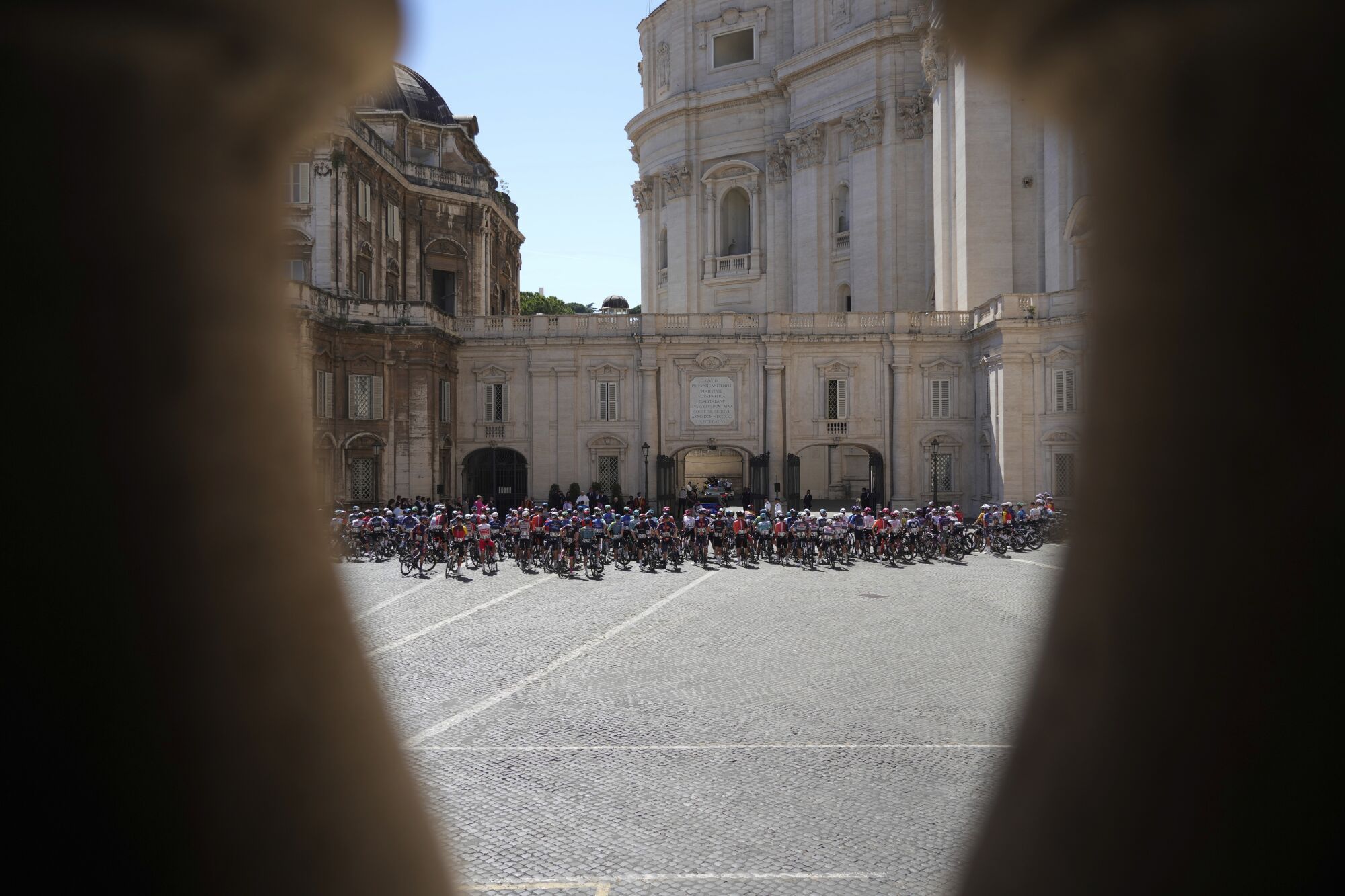 Pope Leo XIV, small white figure, blesses the pack before the start of the final stage of the Giro d'Italia inside the Vatican, Sunday, June 1, 2025. (AP Photo/Andrew Medichini)