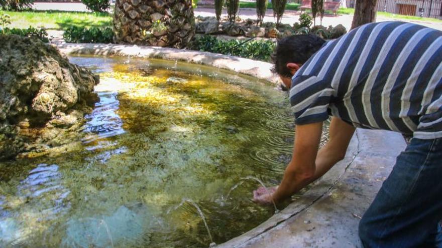 Un hombre refrescándose en un surtidor del parque de la Glorieta en Alcoy