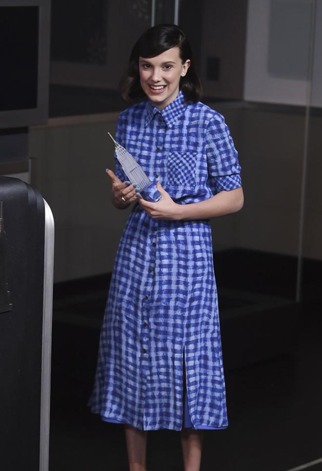 Millie Bobby Brown con vestido a cuadros azul en un acto de UNICEF