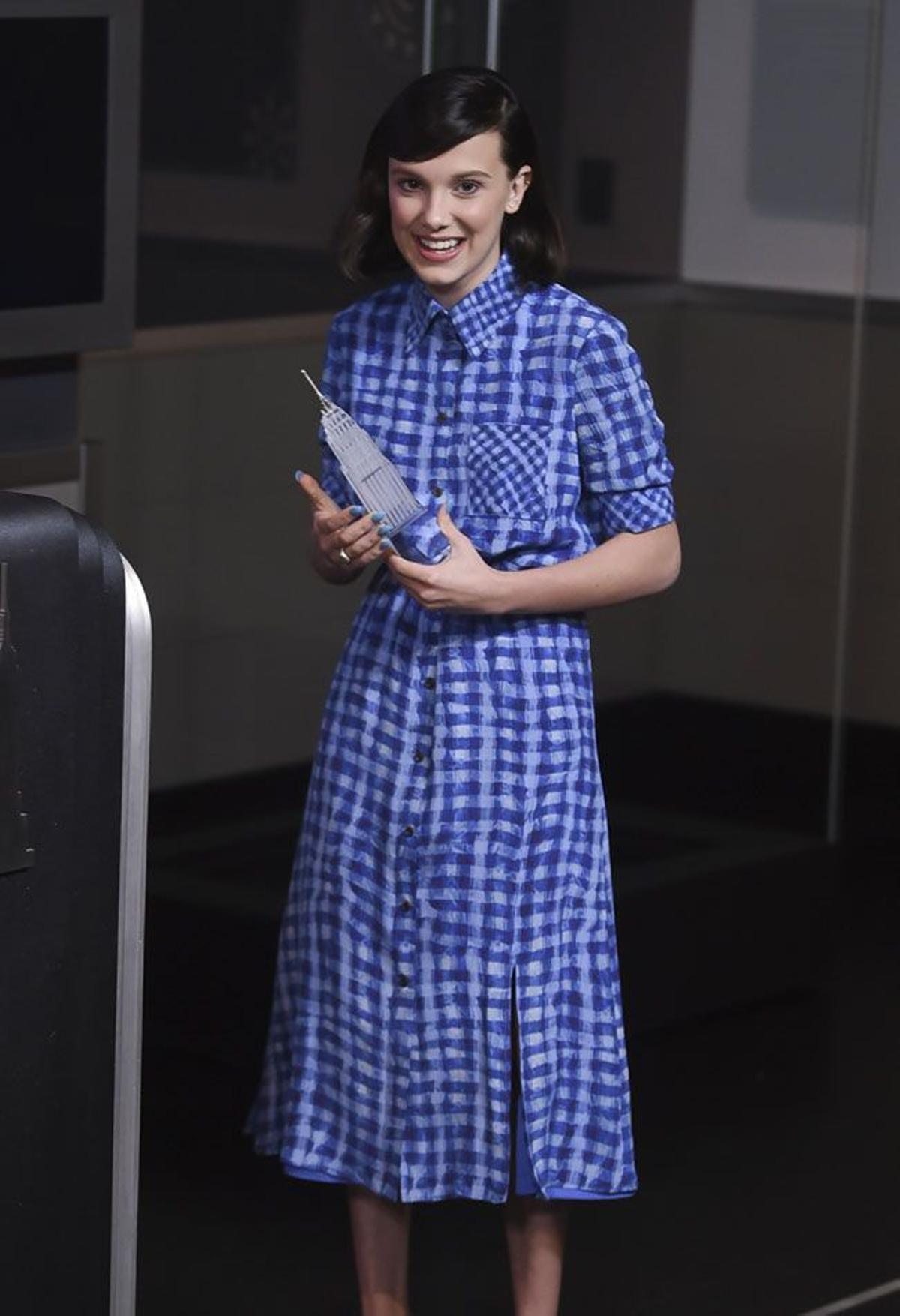 Millie Bobby Brown con vestido a cuadros azul en un acto de UNICEF