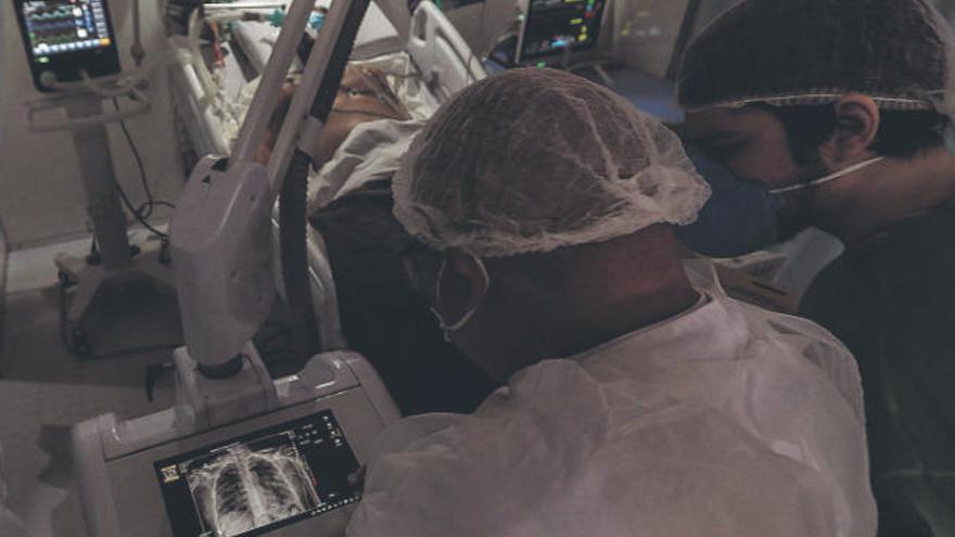 Médicos observan una imagen de rayos x de un paciente con coronavirus en el hospital de Campaña de Riocentro.