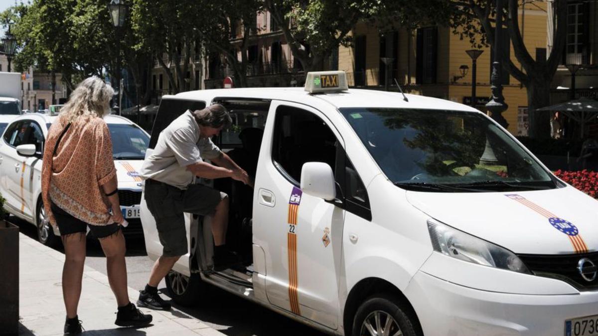 Un taxi recogiendo a pasajeros en el centro de Palma.
