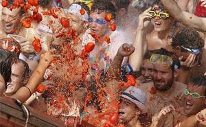 La multitud rep els tomàquets llançats des d’un camió durant la Festa de la Tomatina, a Bunyol (València).