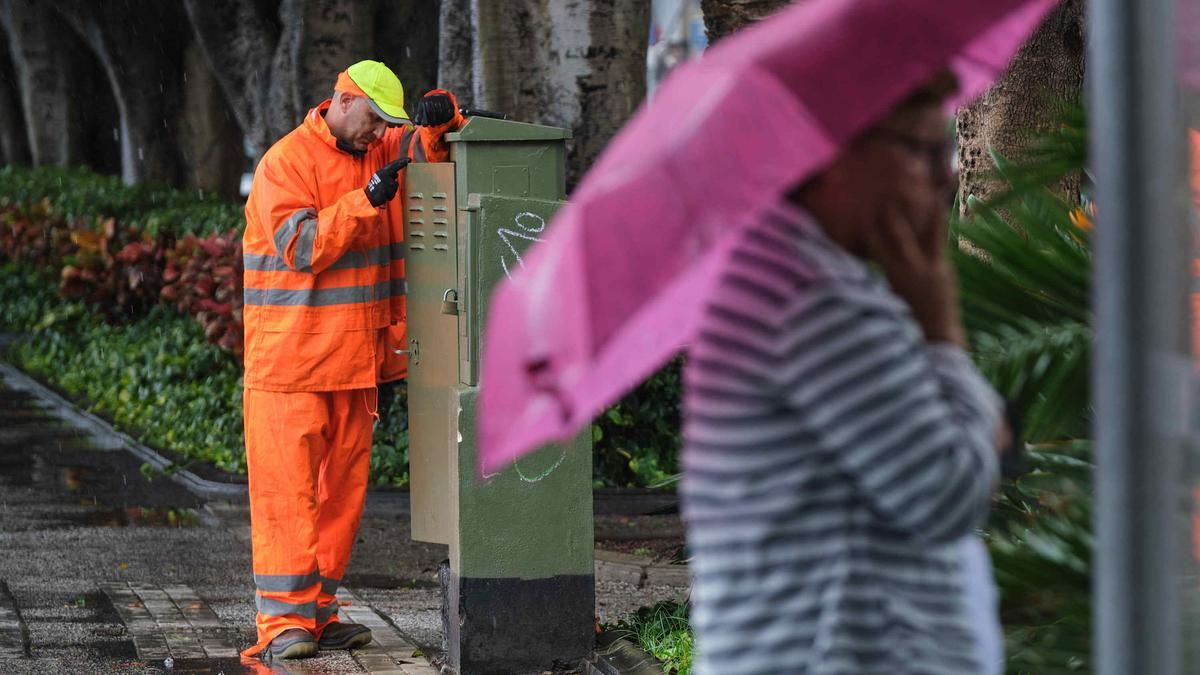 Una mujer se protege de la lluvia en Santa Cruz de Tenerife.