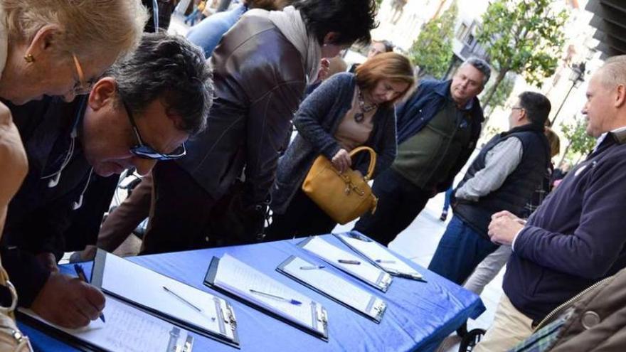 Un momento de la recogida de firmas, ayer, en la mesa de la calle Uría. laura caraduje