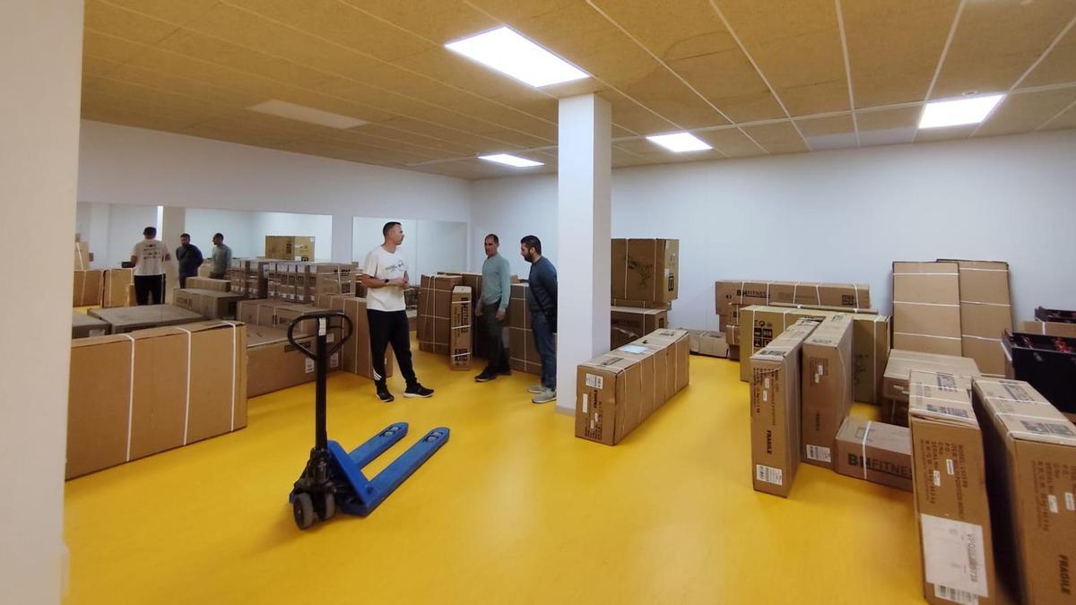 Uno de los responsables de Viraxes con los concejales Ricardo Verde (Deportes) y Xosé Leal (Facenda e Contratación Pública) durante el traslado de las máquinas para las salas de gimnasio de la piscina de As Lagoas, en Bueu.