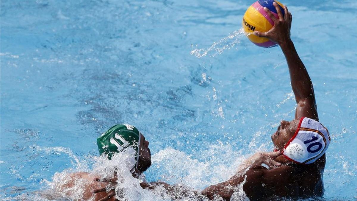 Francisco Fernández (d) pugna con el sudafricano Nicholas Molyneux durante el partido de la fase preliminar de waterpolo