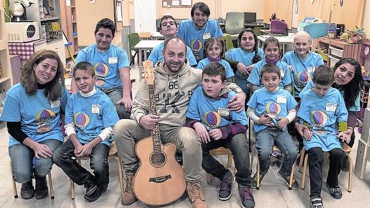 El guitarrista Manuel Hernández, con un grupo de niños afectados por autismo.