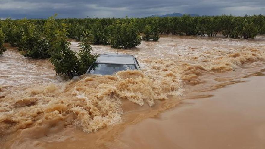 Un coche es engullido por las aguas durante un episodio de fuertes lluvias en Alginet.