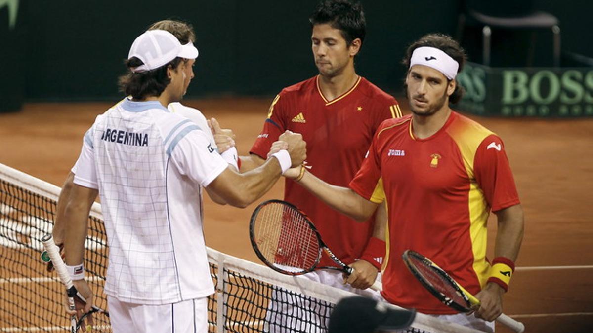 Los tenistas argentinos David Nalbandian (izquierda, detrás) y Eduardo Schwank (izquierda) saludan a los tenistas Feliciano López (derecha) y Fernando Verdasco, tras vencer el tercer partido de la final de la Copa Davis.
