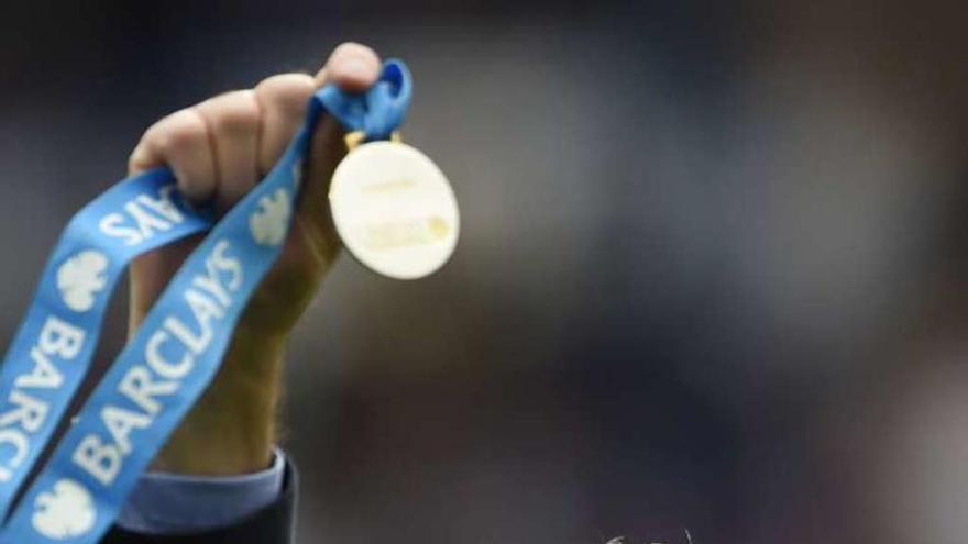 Mourinho muestra la medalla de oro tras ganar la Premier.