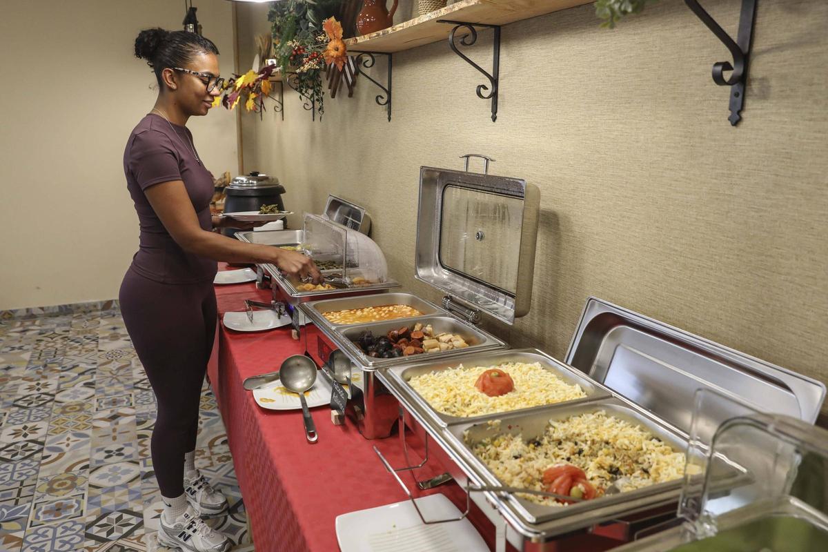 Una comensal sirviéndose en el buffet libre