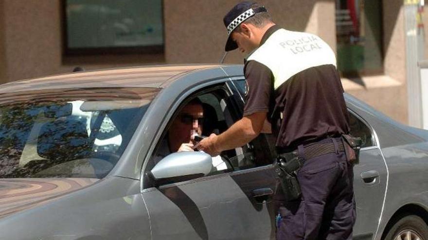 Un agente de la Policía Local realiza una prueba de la alcoholemia a un conductor.  // Rafa Vázquez