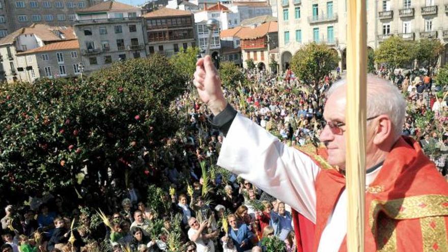 La multitud alza sus palmas y ramos en A Ferrería para recibir la bendición de Jaime Vaamonde, párroco de Santa María.