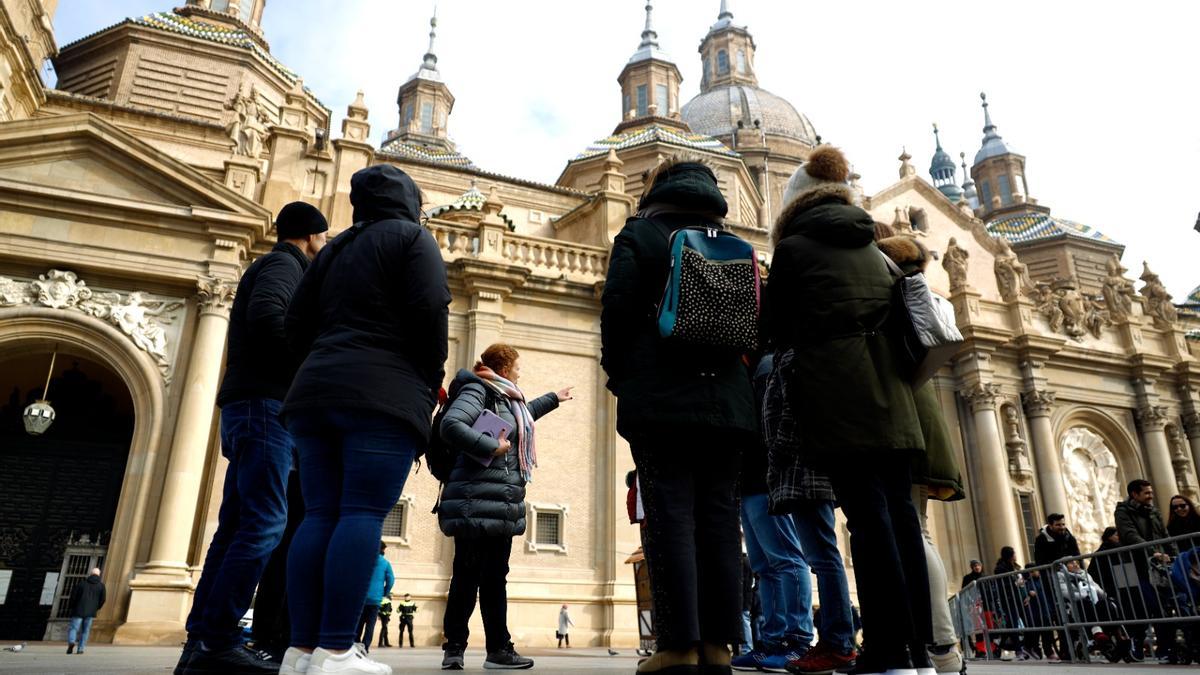 La guía explica al grupo de turistas el lugar en el que la tradición cuenta que se apareció la Virgen en Zaragoza.
