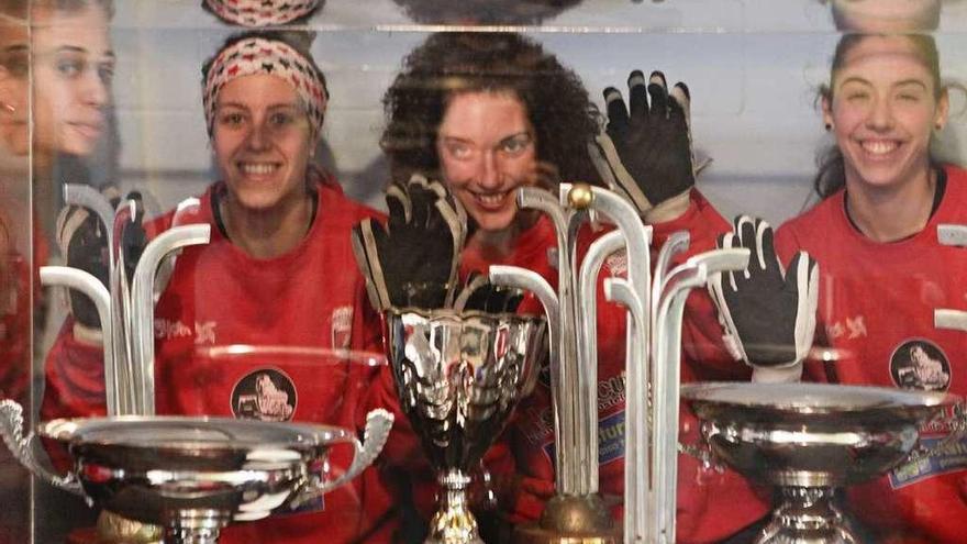 Sara González, María Díez, Anna Casarramona y Marta González tras la vitrina con los trofeos.