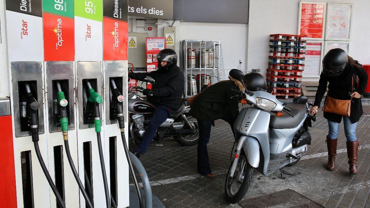 Una gasolinera con varios clientes repostando.