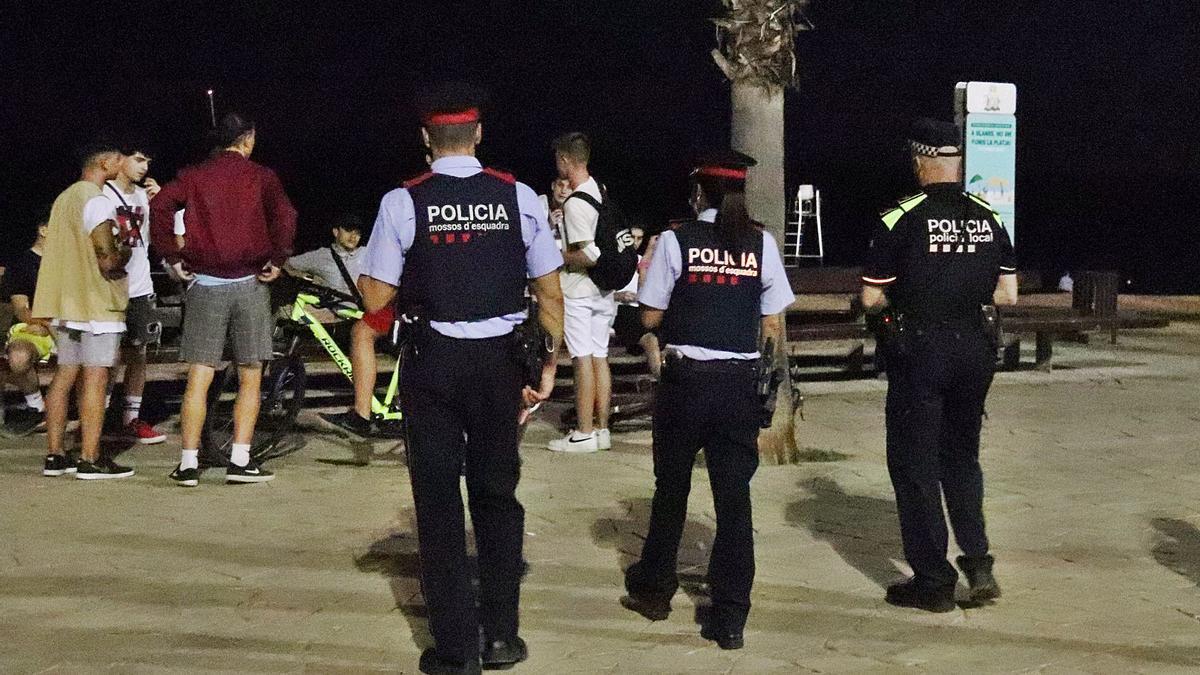 Una patrulla de Mossos dissuadint un grup de joves que fan «botellón» al passeig marítim de Blanes en una imatge d&#039;arxiu.