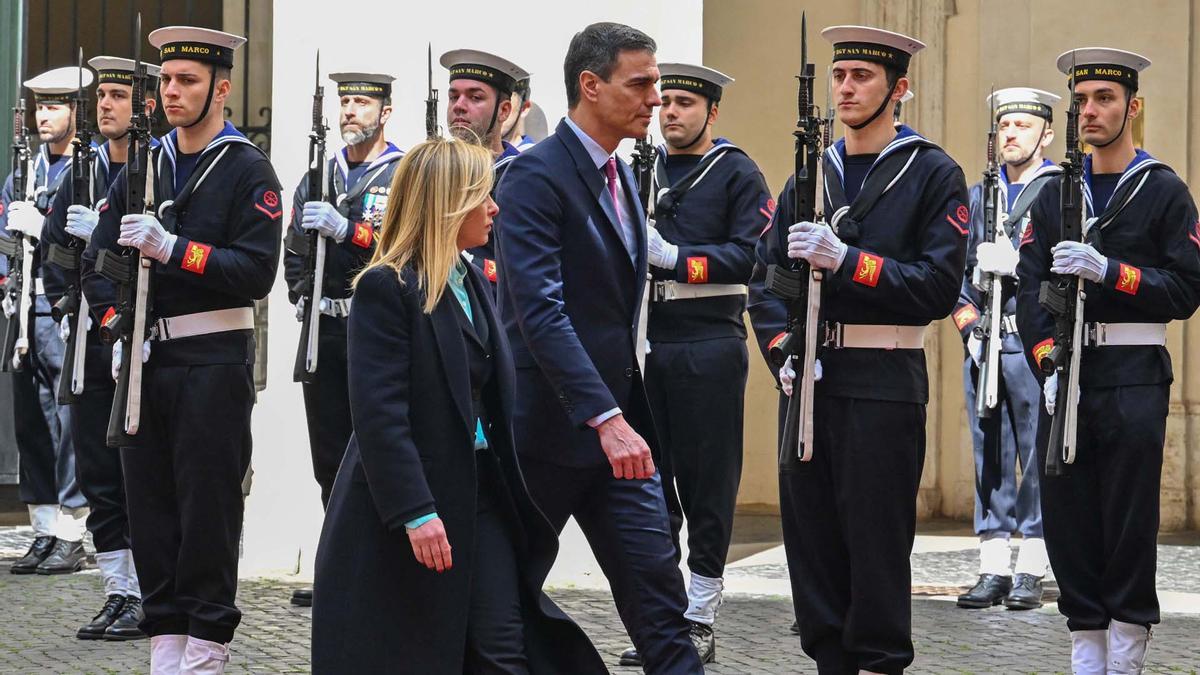 La primera ministra de Italia, Giorgia Meloni, y su homólogo español, Pedro Sánchez, revisan las tropas durante una ceremonia de bienvenida el 5 de abril de 2023 a la llegada de Sánchez para su reunión en el Palazzo Chigi de Roma. (Foto de Andreas SOLARO / AFP)