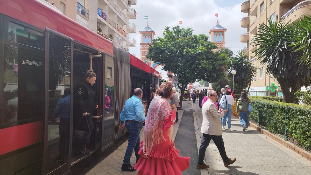 Una mujer con traje de flamenca se baja del autobús de Tussam para ir a la Feria de Sevilla. El Ayuntamiento estudia crear una lanzadera desde Sevilla Este