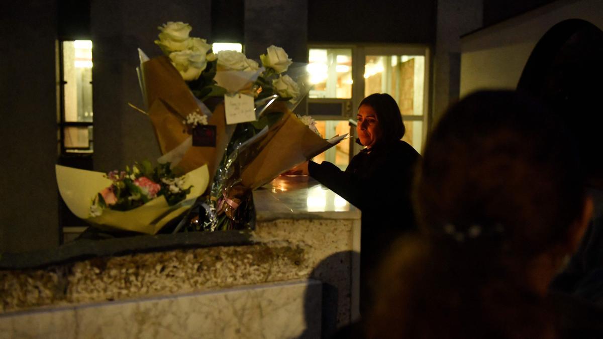 Una mujer enciende una vela al pie del edificio donde fue encontrado el cadáver de una niña de 12 años el el distrito 19 de París