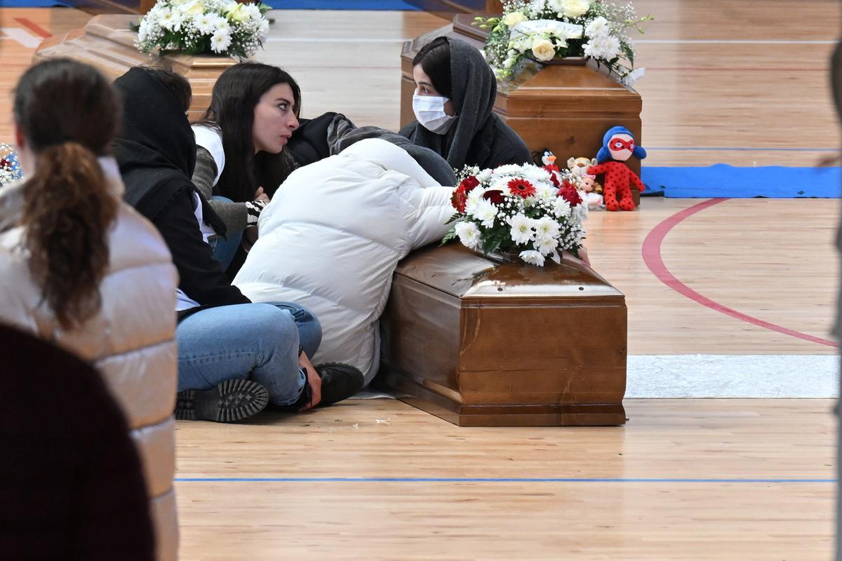 Familiares junto a los ataúdes de las 65 víctimas de un devastador naufragio de inmigrantes frente a la costa sur de Italia