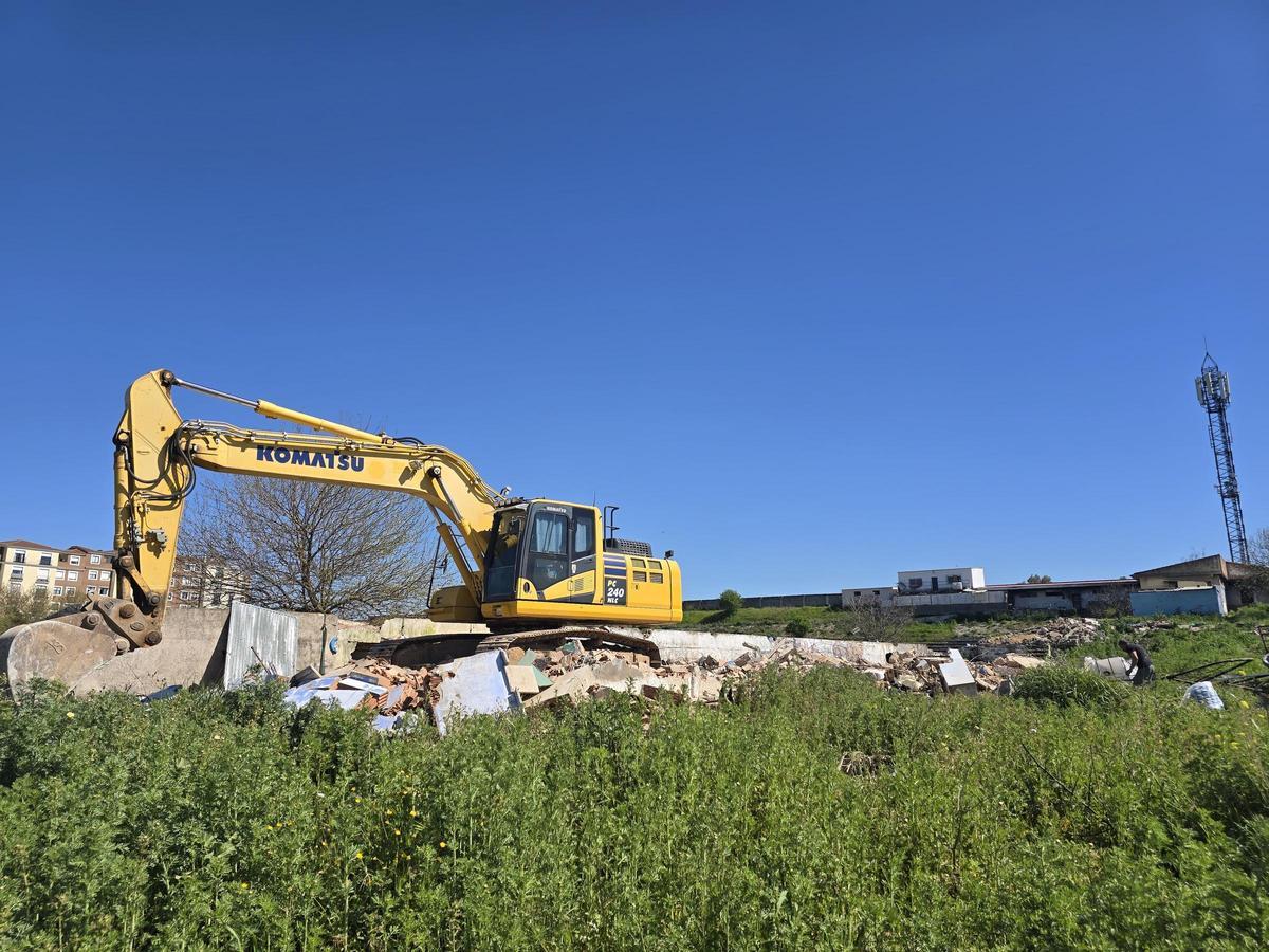 La máquina derriba uno de los muros laterales más cercanos al cementerio, este martes.