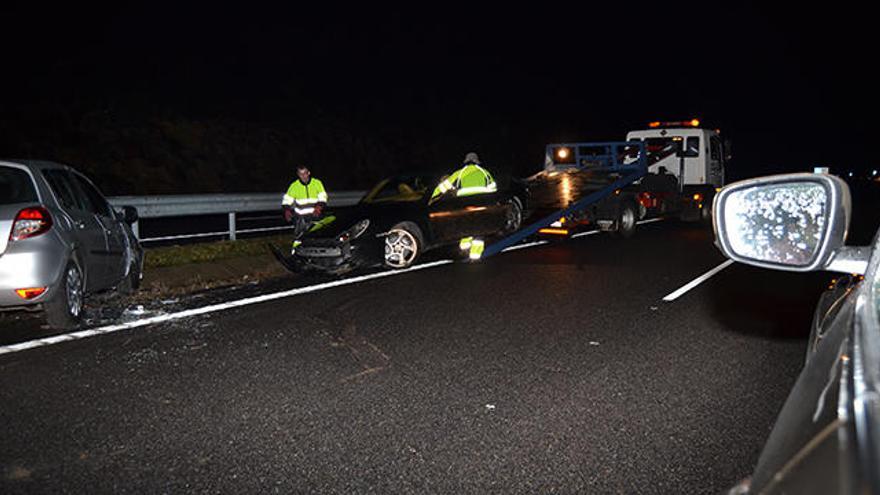 La grúa retira uno de los coches implicados tras el siniestro.