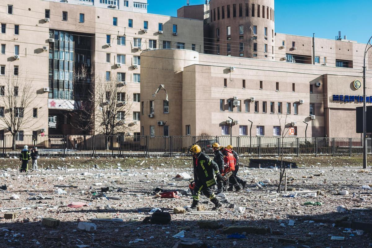 Bomberos y servicios de emergencia en las inmediaciones del edificio civil bombardeado en Kiev.