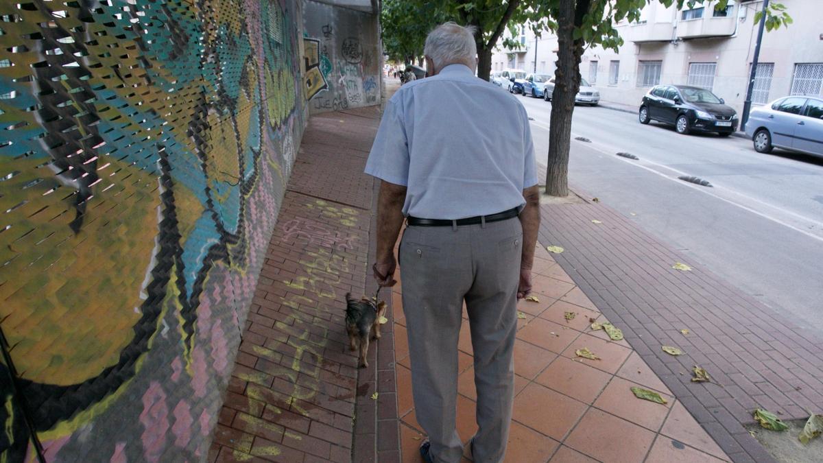 Un jubilado pasea por una calle de Murcia.