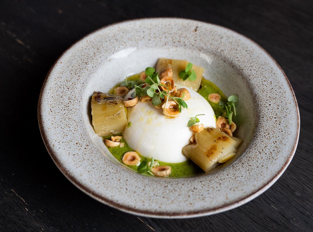 Burrata con puerro asado a la brasa, avellanas y pesto en el restaurante Caluana.