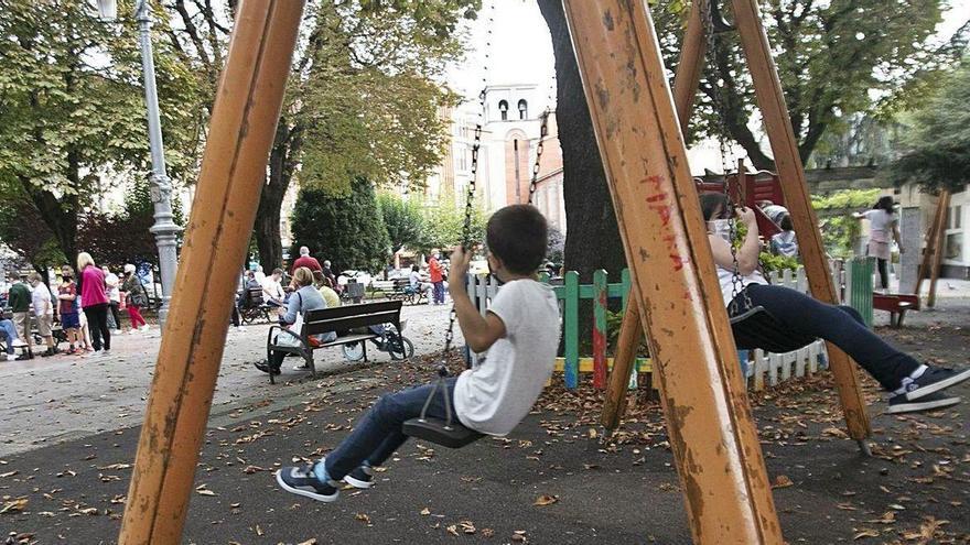 Dos niños, en el parque Dolores F. Duro de La Felguera, poco después de decretarse la alerta naranja y antes del cierre de los espacios infantiles.