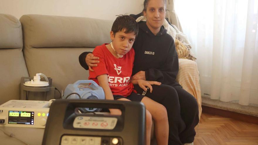 Alexia Hermida y su hijo, Miguel, con las máquinas de oxígeno del pequeño, en su casa. | I. López