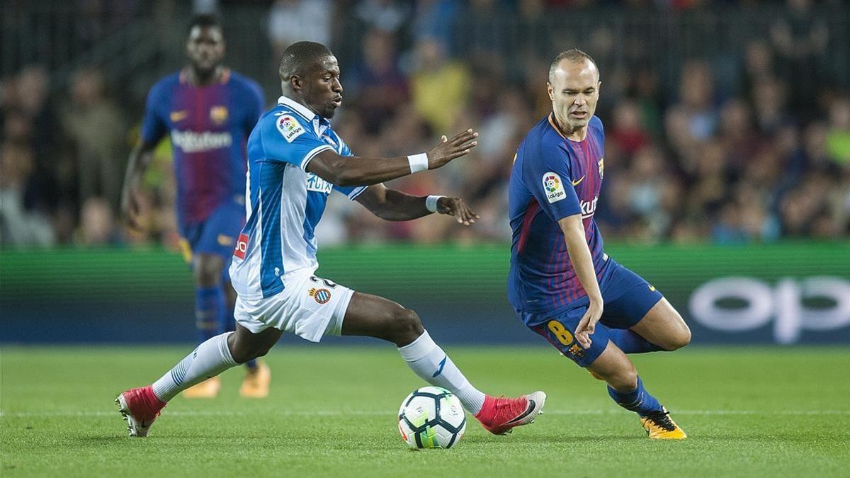 Iniesta supera a Diop en el derbi contra el Espanyol en el Camp Nou.