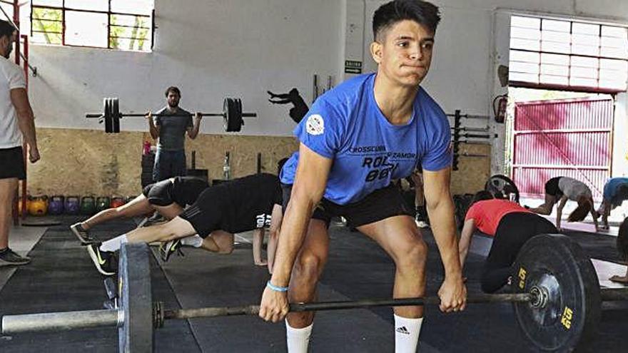 Rodrigo García levanta un peso de entrenamiento durante el calentamiento.