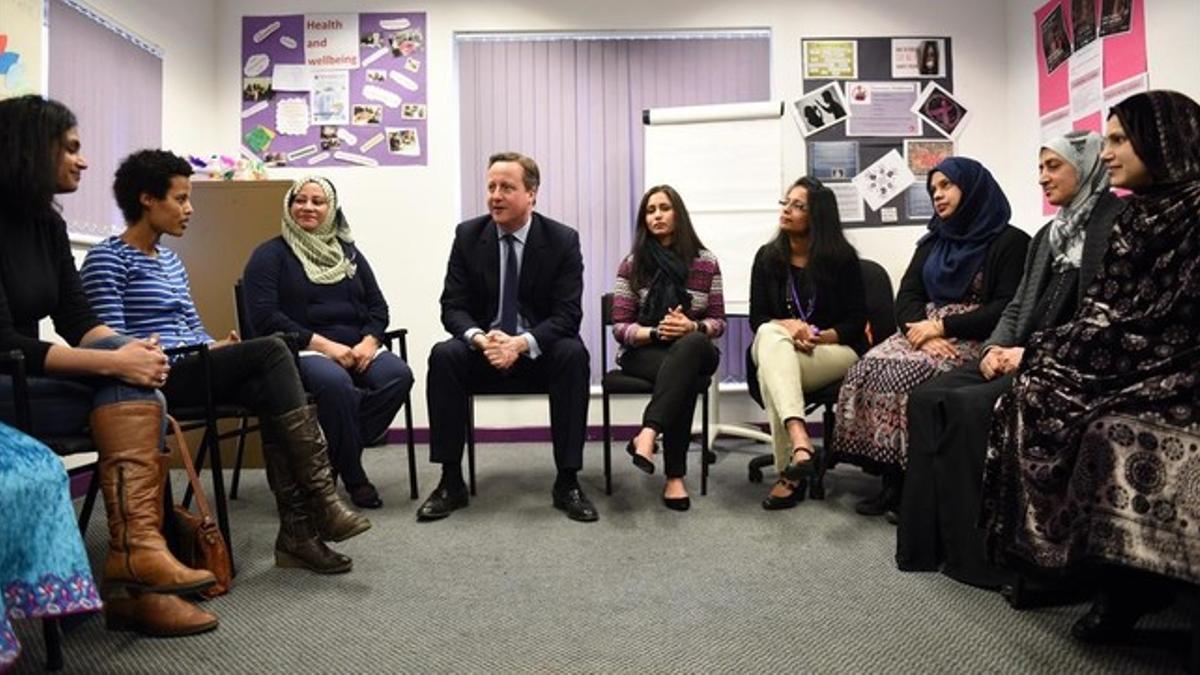 Cameron (centro) habla con mujeres que siguen clases de inglés en un centro de Leeds, este lunes.