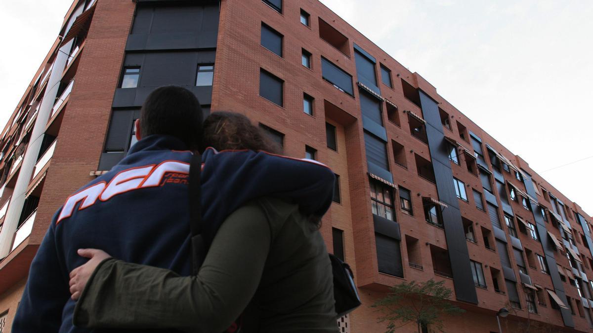 Dos jóvenes contemplan un bloque de pisos en la provincia de Alicante.